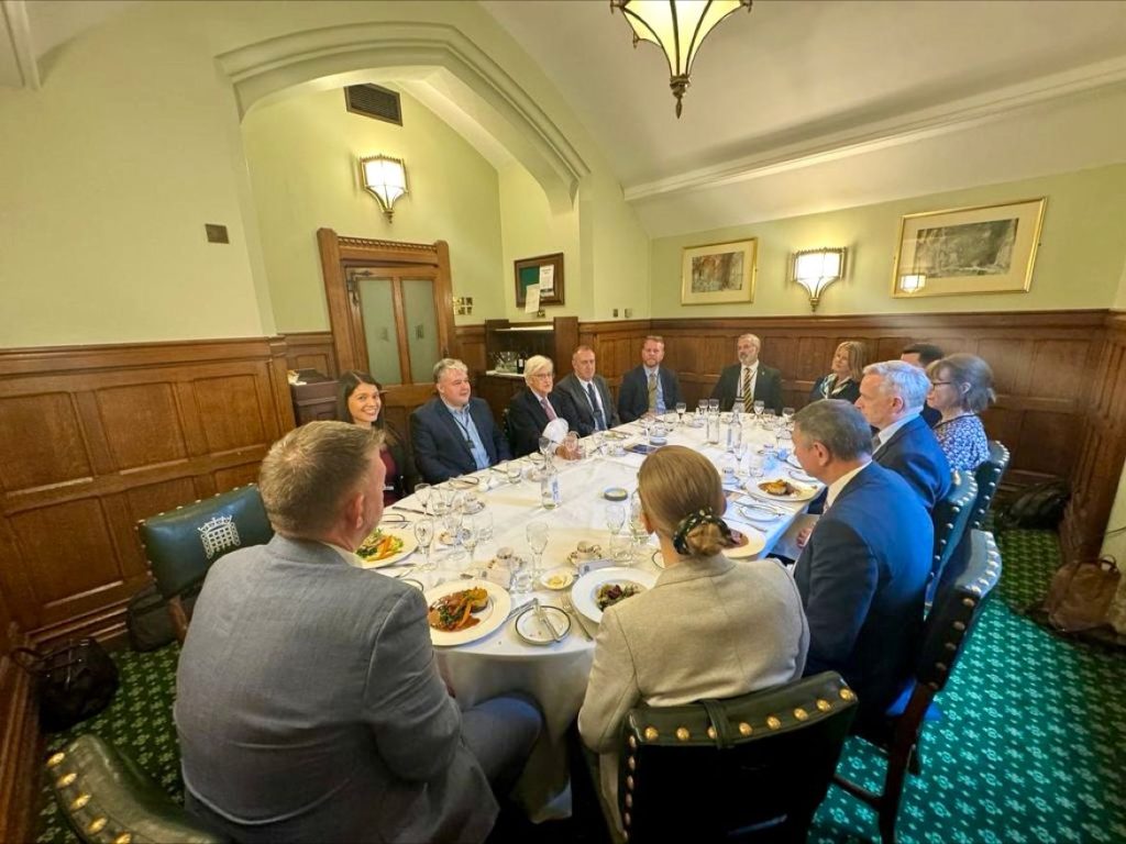 A group of people sat around a table in Parliament discussing the Baker Award