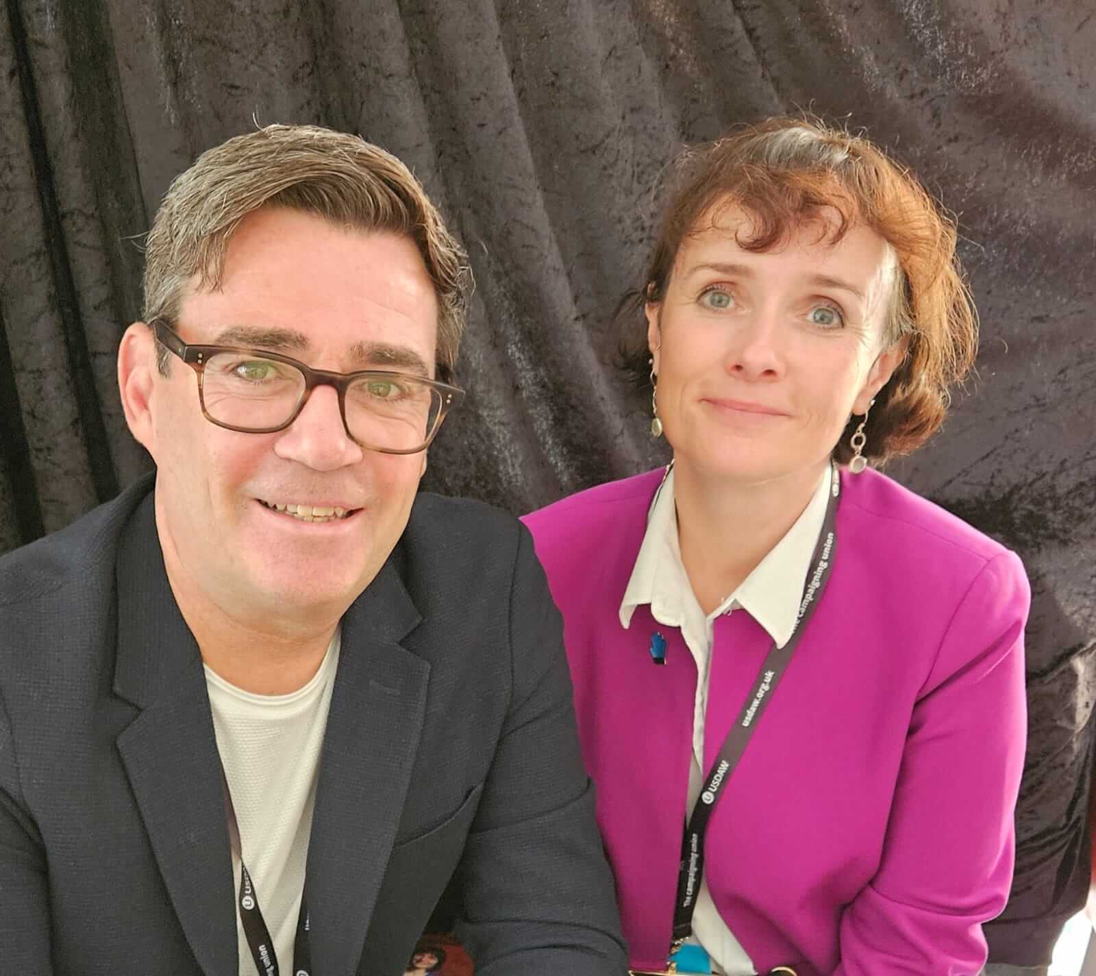 Andy Burnham sat in front of Kate Ambrosi before a black curtain background.