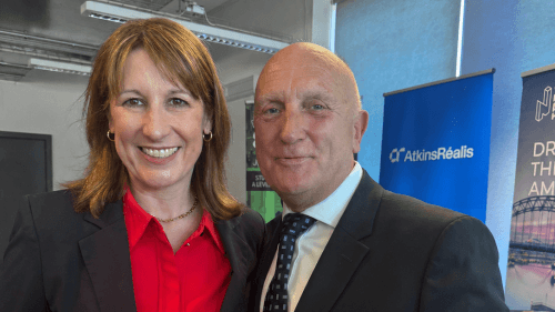 Rachel Reeves stood next to Stephen Phipson in a classroom, both looking at the camera. An AtkinsRéalis banner sits behind Phipson's shoulder.